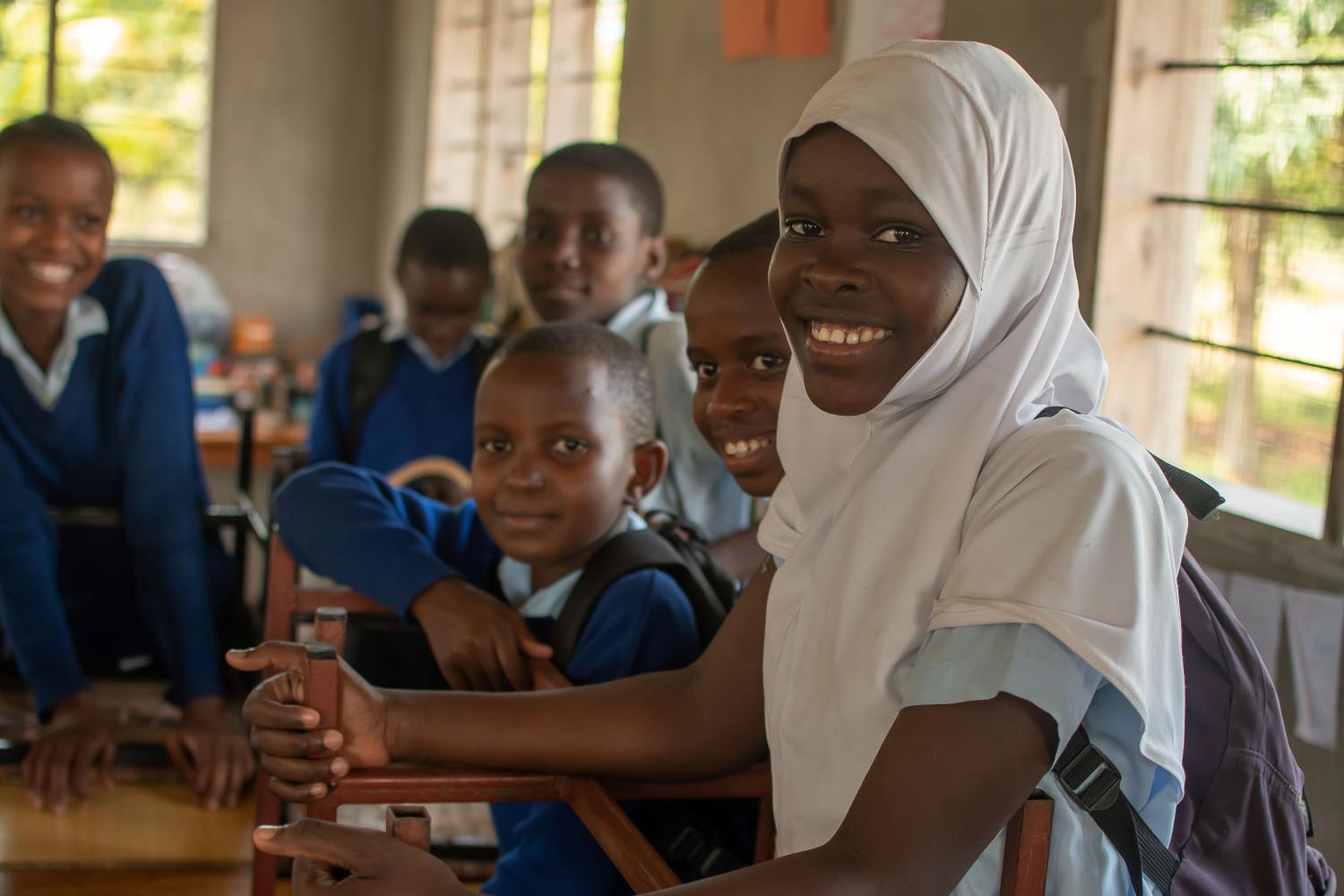 Dodoma, Tanzania. 08-18-2019. Portrait of a group of children at school looking smiling at the camera after packing their things and ready to leave on their way home.