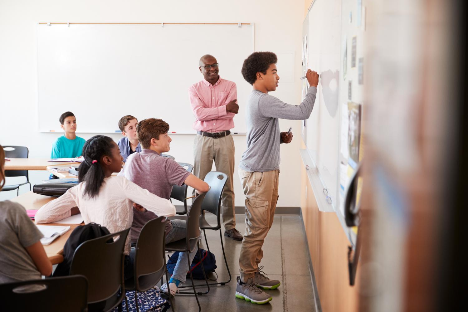 student at whiteboard in classroom