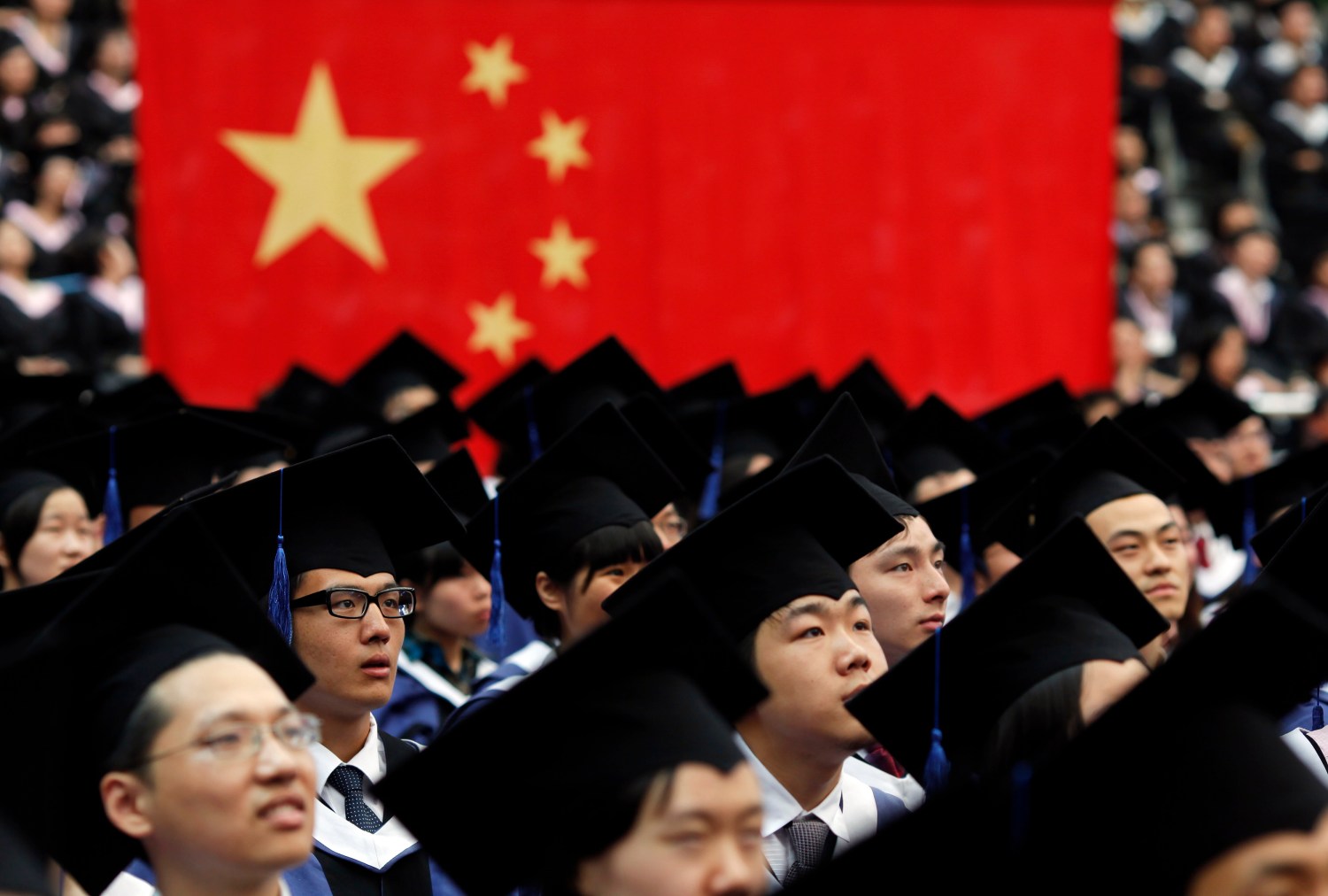 Students attend their college graduation ceremony in Shanghai's Fudan University  July 2, 2011. China began expanding university enrollment in 1996 to meet growing personnel demands as the economy boomed, but Xinhua News Agency has reported concerns by the Chinese State Council over creating enough jobs for millions of college students who will graduate between 2011 and 2015. University education is a key component of China's goal to create a broad urban tier of middle class families with "well-off characteristics" nationwide. China produces about 830,000 college graduates every year. REUTERS/Carlos Barria (CHINA - Tags: POLITICS EDUCATION)