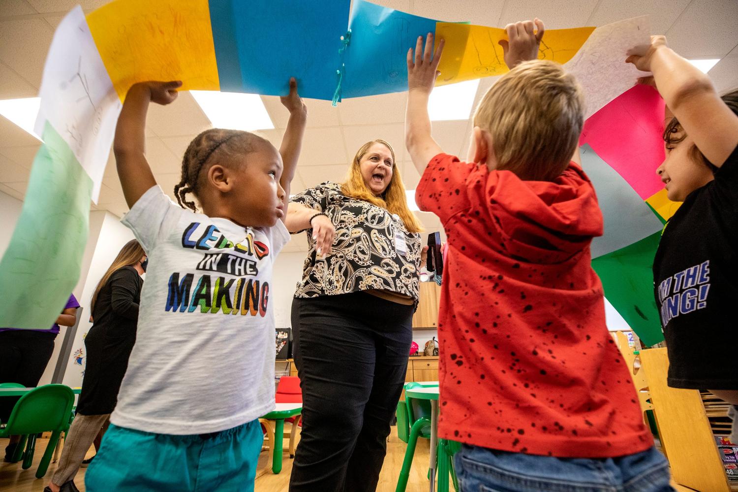 Pre K students Malakai Ruth , Maverick McClelland and Liam Vardales , right help Sheila Chambers carry the Kindness Quilt made of drawings of what the preschoolers thought kindness looked like during a presentation at the Pre K class at the YMCA Innovation Hub in Lakeland Fl. Monday Oct. 25 2021.Early Learning Coalition is teaching pre-K students about social and emotional skills to stop bullying.  ERNST PETERS/ THE LEDGER102521 Ep Kind 1 News