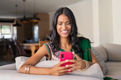 A woman at home uses her phone to talk to a mentor.