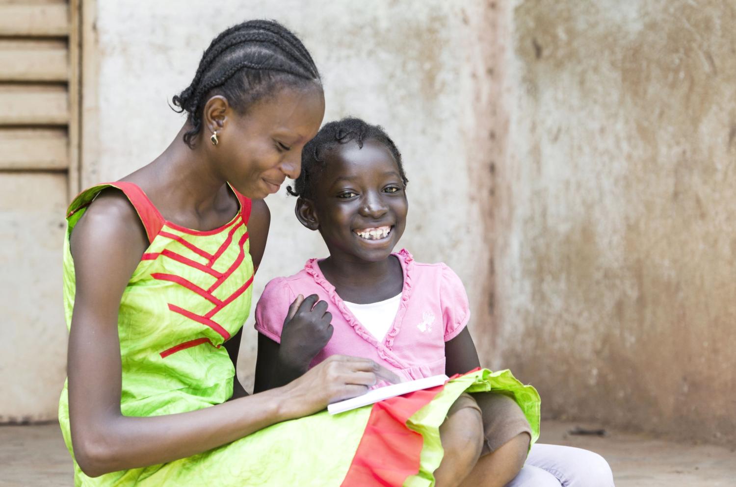 A child and her mother read on the front steps.