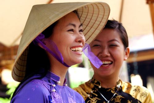 A Vietnamese woman wears traditional "ao dai" dress and a conical hat in downtown's Vietnam's central city of Da Nang.  A Vietnamese woman wears traditional "ao dai" dress and a conical hat in downtown Vietnam's central city of Da Nang March 8, 2005. 40 years after the first American troops arrived in Da Nang on March 8, 1965 to fight in the Vietnam War which cost 58,000 American and 3,000,000 Vietnamese lives, a U.S. military team of about 100 flew into Da Nang early this month as part of continuing U.S. efforts to locate about 1,800 soldiers still listed as missing. REUTERS/Kham