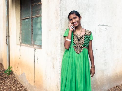 A young woman in India talks to her mentor on the phone.