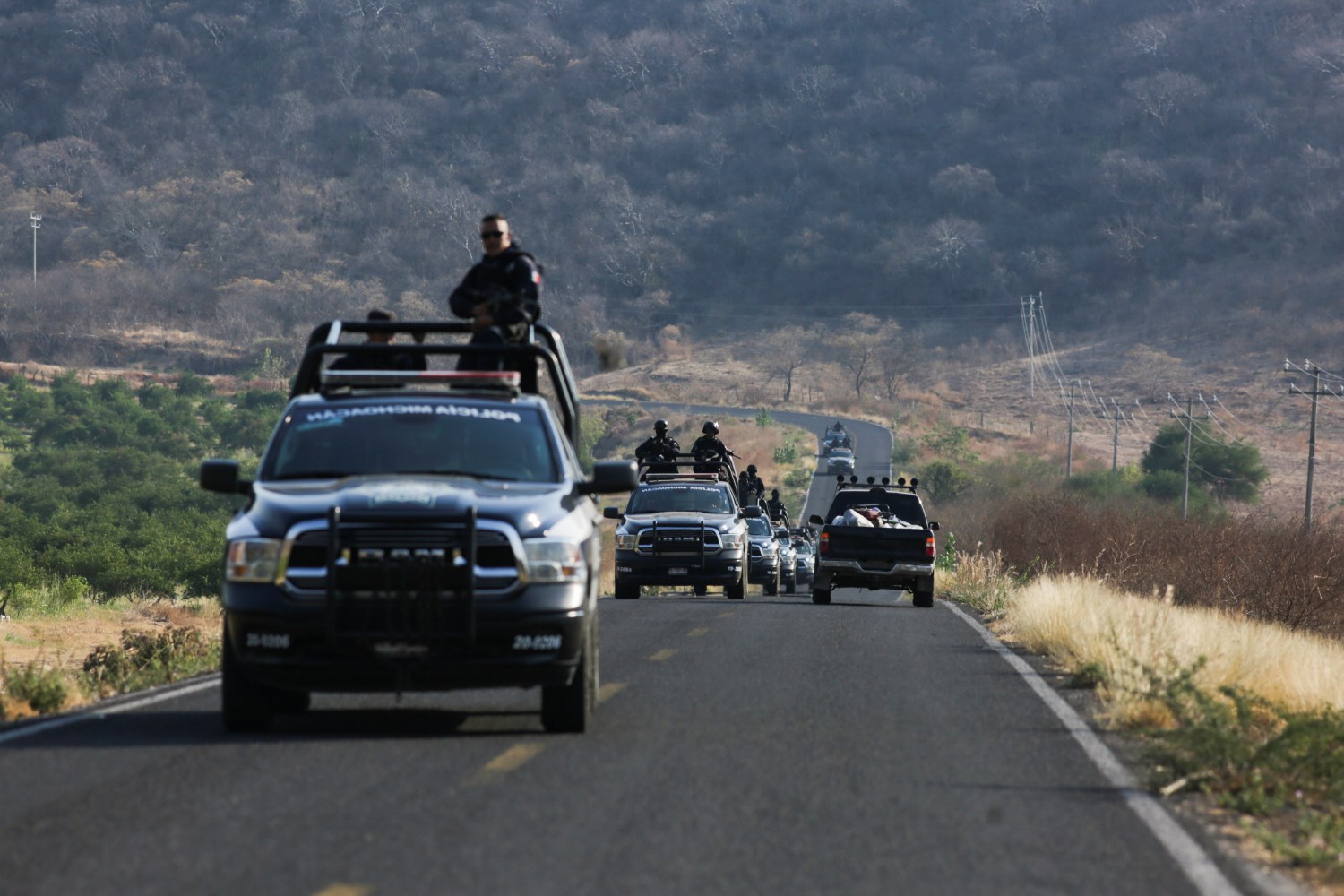 A State police convoy patrols a road in El Aguaje after a visit of Vatican's ambassador to Mexico Franco Coppola to the area and to the municipality of Aguililla, an area where the Jalisco New Generation Cartel (CJNG) and local drug gangs are fighting to control the territory, in Michoacan state, Mexico April 23, 2021. REUTERS/Alan Ortega