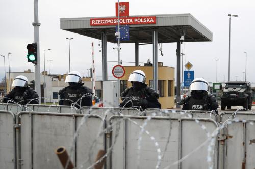 Polish police officers stand guard at Bruzgi-Kuznica checkpoint on the Belarusian-Polish border, as seen from the Grodno region, Belarus, November 22, 2021. REUTERS/Kacper Pempel