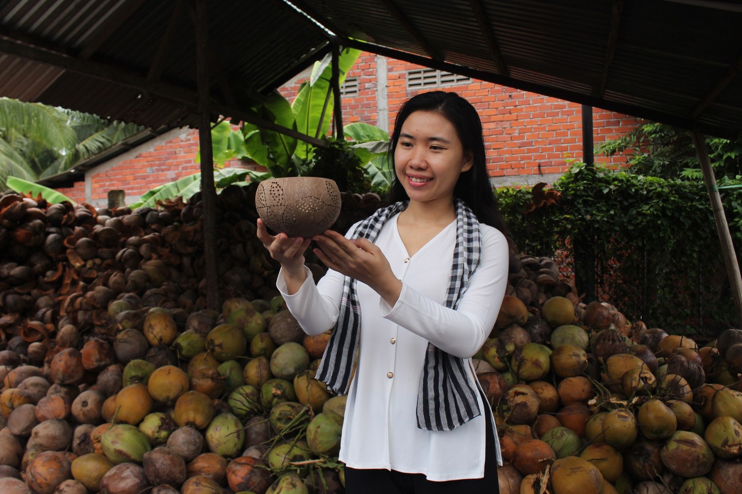 An entrepreneur in Vietnam holds a bowl she made.
