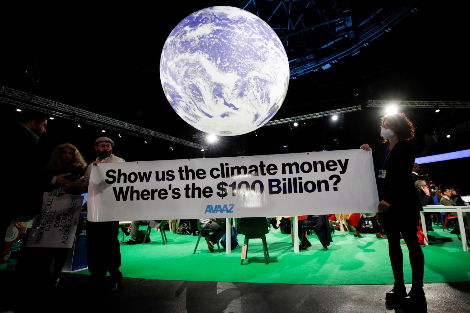 FILE PHOTO: Avaaz activists hold a sign during the UN Climate Change Conference (COP26), in Glasgow, Scotland, Britain, November 5, 2021. REUTERS/Phil Noble/File Photo