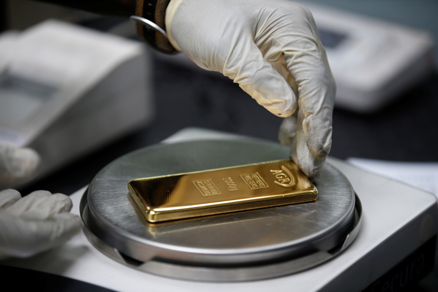 An employee weighs a 1kg gold bar at AGR (African Gold Refinery) in Entebbe, Uganda, October 4, 2018. Picture taken October 4, 2018. To match Insight AFRICA-GOLD/REFINERIES     REUTERS/Baz Ratner