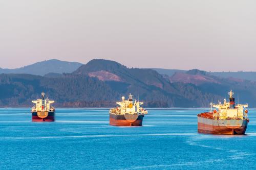 Fleet of commercial ships sailing on the ocean.