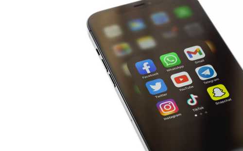 Phone showing social media mobile app icons of Facebook, WhatsApp, YouTube, Instagram, TikTok, Snapchat, Telegram, Twitter on display iPhone. Moscow, Russia - December 5, 2020