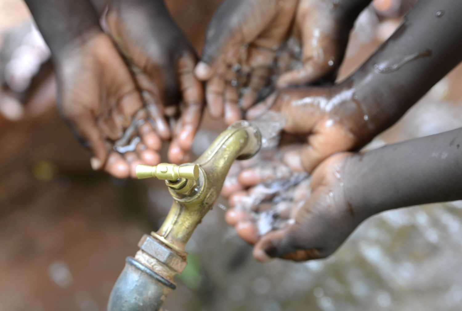 Hands catching water running from a tap