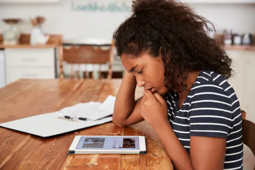 Teenage Girl At Home Using Digital Tablet Being Bullied On Line