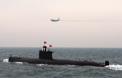 A military aircraft flies past a Chinese Navy submarine at an international fleet review to celebrate the 60th anniversary of the founding of the People's Liberation Army Navy in Qingdao, Shandong province April 23, 2009. REUTERS/Guang Niu/Pool (CHINA POLITICS MILITARY)