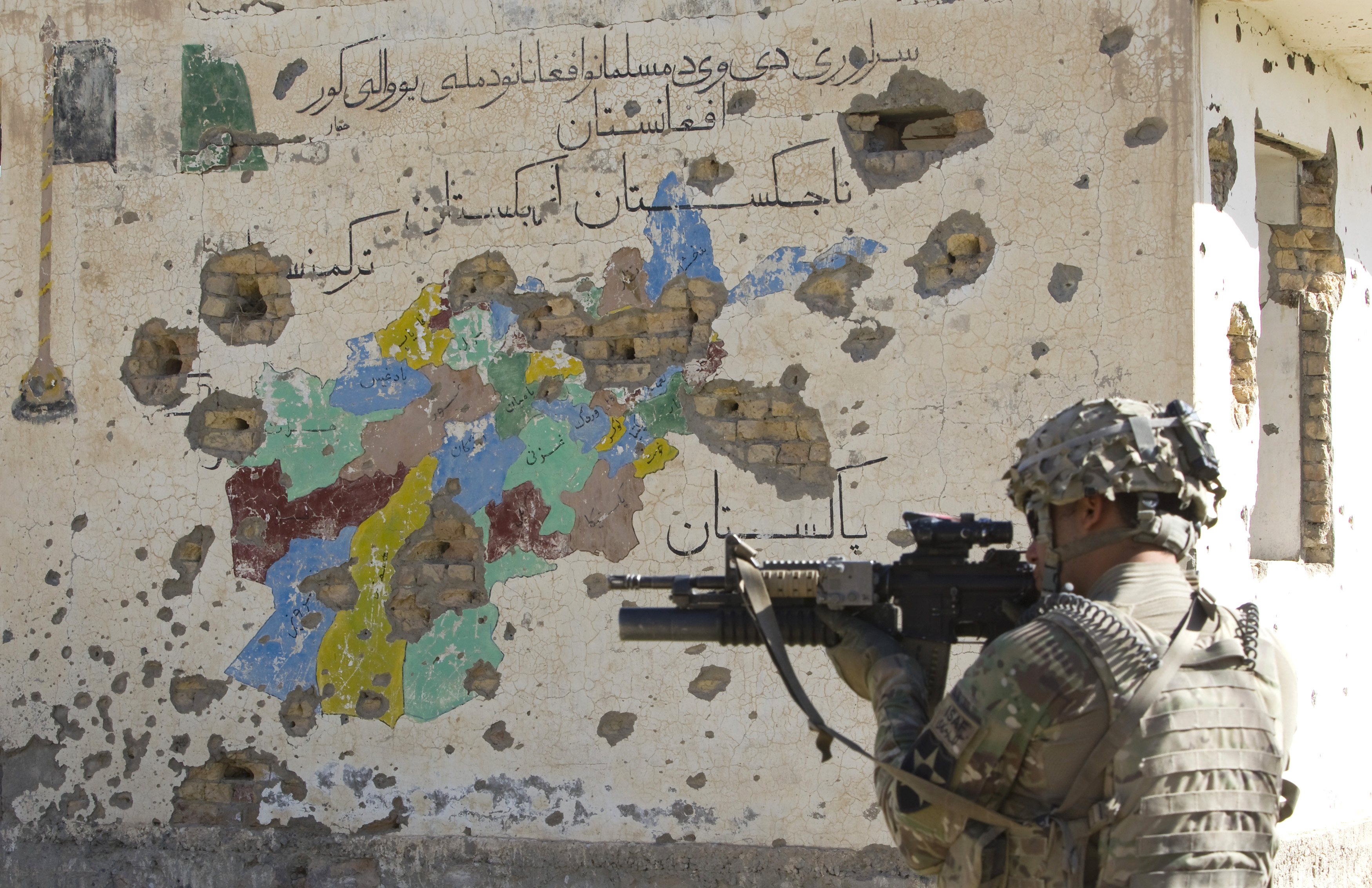 A U.S. Army soldier of 5-20 Infantry Regiment attached to 82nd Airborne Division, aims his rifle in front of a bullet riddled map of Afghanistan painted on a wall of an abandoned Canadian-built school in the Zharay district of Kandahar province, southern Afghanistan June 9, 2012.  REUTERS/Shamil Zhumatov  (AFGHANISTAN - Tags: MILITARY CIVIL UNREST POLITICS)