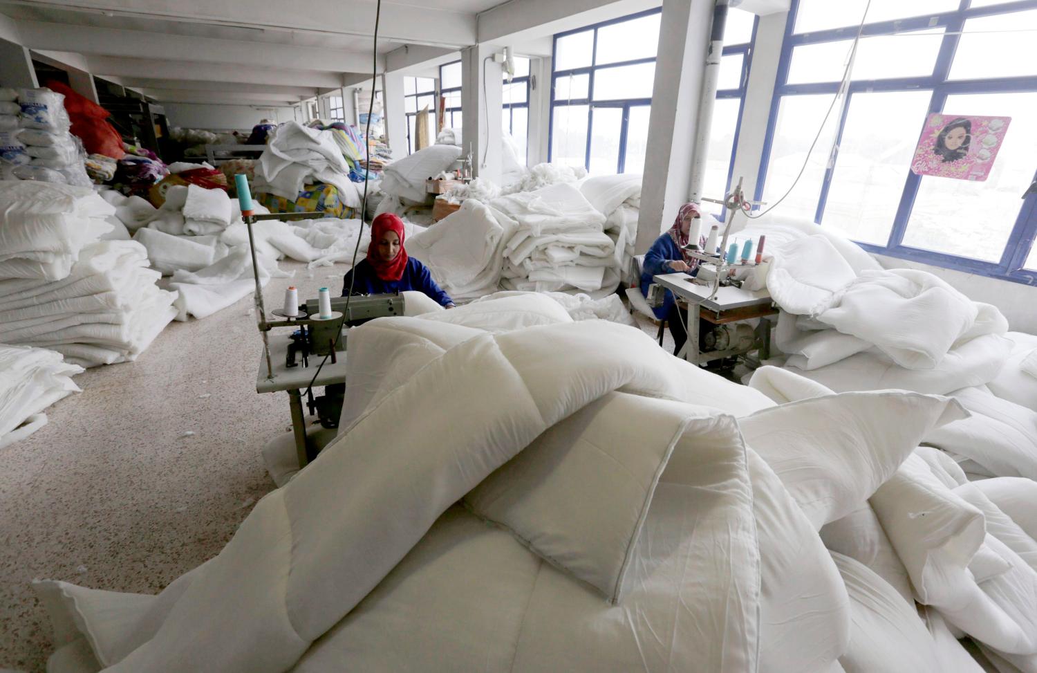 A worker sews blankets made from recycled plastic bottles at a recycling plant in Chelghoum Laid, 360 km (224 miles) east of Algiers February 26, 2014. Picture taken February 26, 2014. REUTERS/Louafi Larbi  (ALGERIA - Tags: ENVIRONMENT SOCIETY)