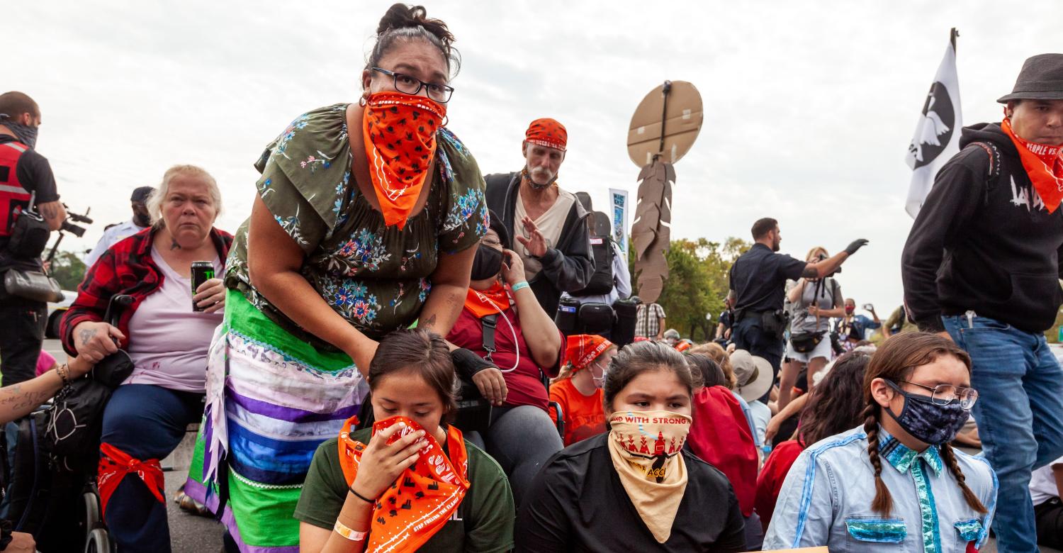 An indigenous elder braids the hair of a child while they await arrest at the US Capitol during a youth-led civil disobedience action against the continued use of fossil fuels, on the fifth and final day of a week of action hosted by People vs. Fossil Fuels.  Protesters have two major demands of the Biden Administration; cease approvals of projects for fossil fuel infrastructure and lead a renewable energy transformation. (Photo by Allison Bailey/NurPhoto)NO USE FRANCE