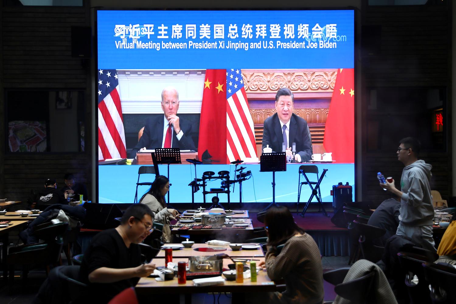 FILE PHOTO: A screen shows Chinese President Xi Jinping attending a virtual meeting with U.S. President Joe Biden via video link, at a restaurant in Beijing, China November 16, 2021. REUTERS/Tingshu Wang/File Photo