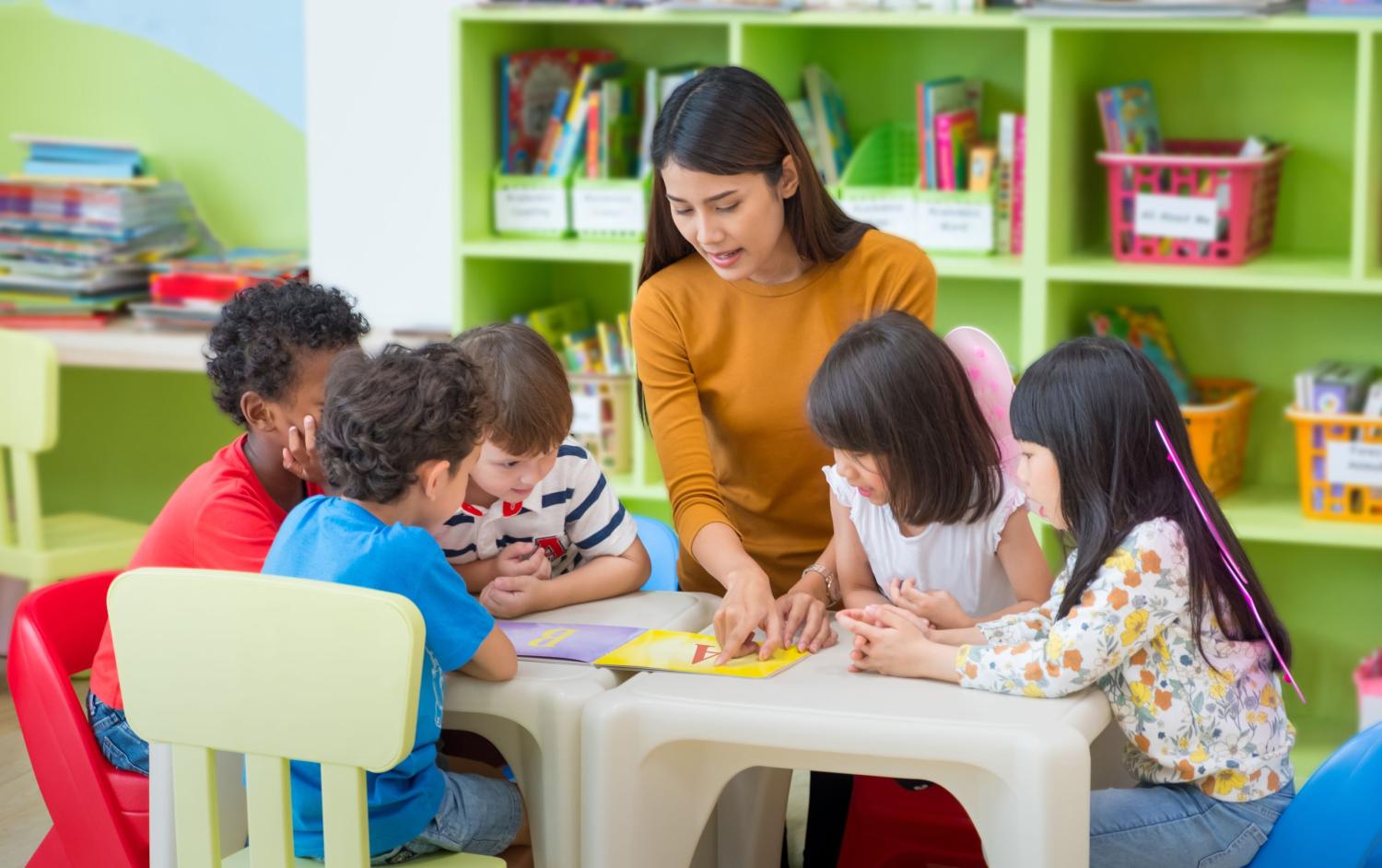 preschool children gather around a table.