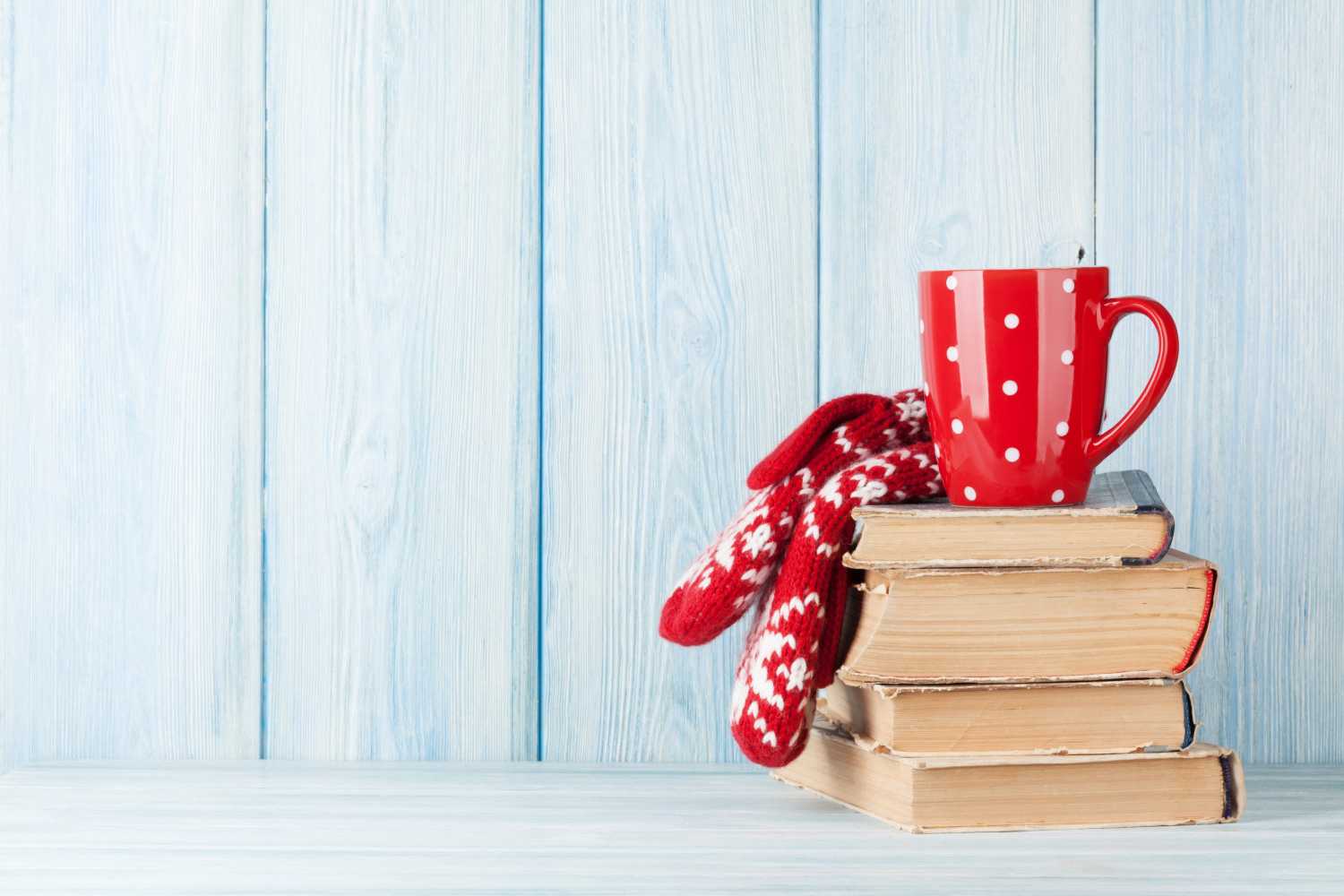 Mug and gloves sitting atop books