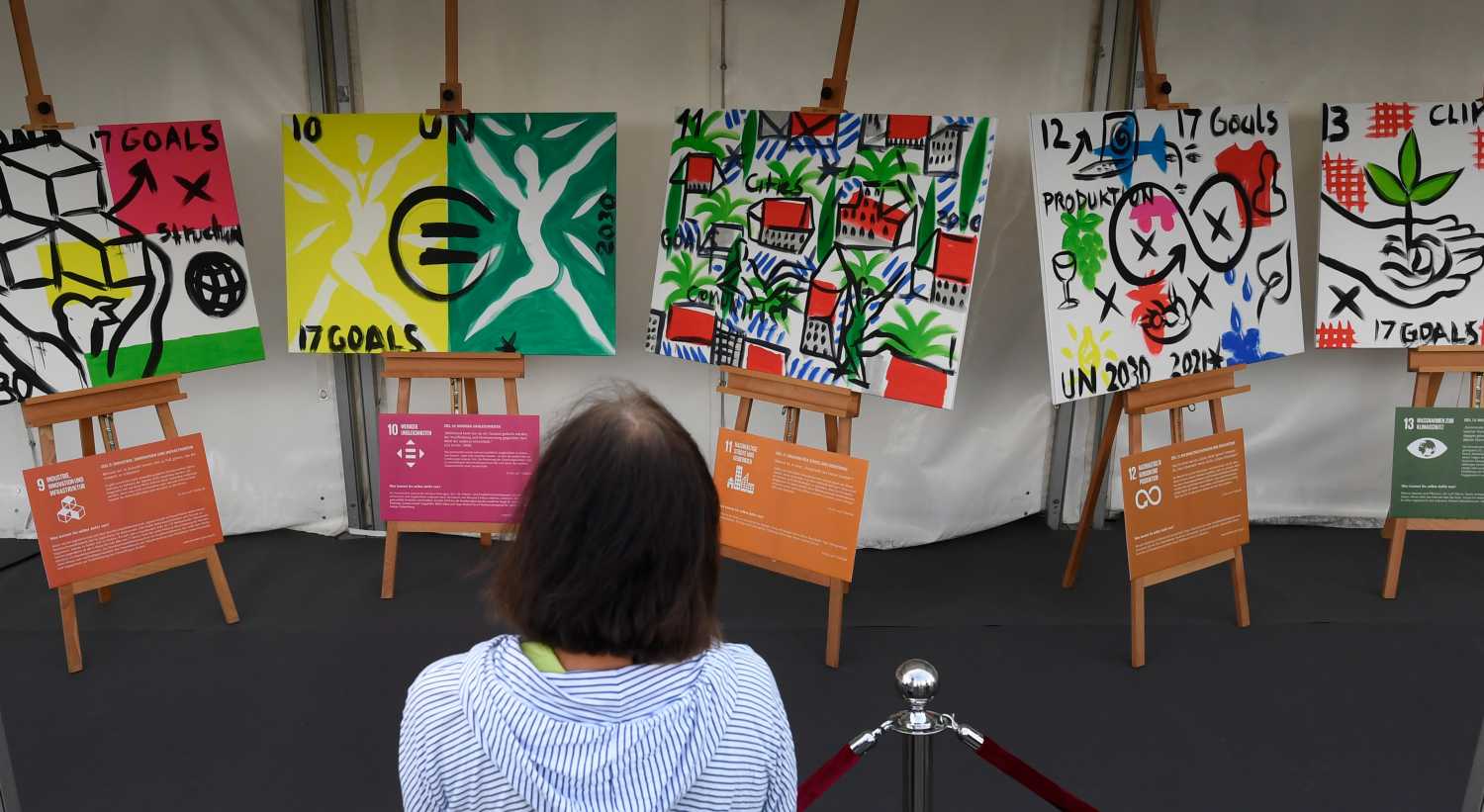 A viewer looks at some preliminary sketches by the visual artist Szczesny. Szczesny started the world's first cultural regatta on the Rhine. The Monheimer Kulturwerke and Szczesny designed 17 sails with the 17 Sustainable Development Goals of the United Nations (UN). The regatta, with boats from the German Sailing League, aims to draw attention to the urgent issues facing our society.
