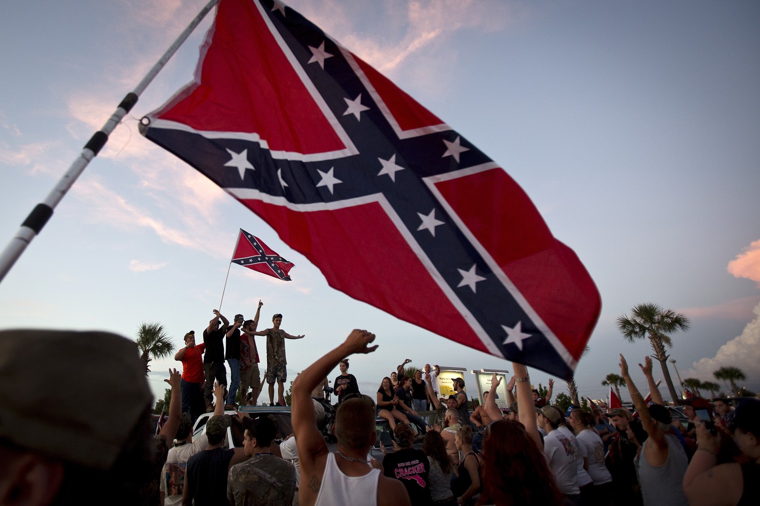 Participants in the "Ride for Pride" event stand on the back of their pickup truck as they speak to an assembled crowd during the impromptu event to show their support the Confederate flag in Brandon, Hillsborough County, June 26, 2015. Several hundred people took part in the event.     REUTERS/Carlo Allegri