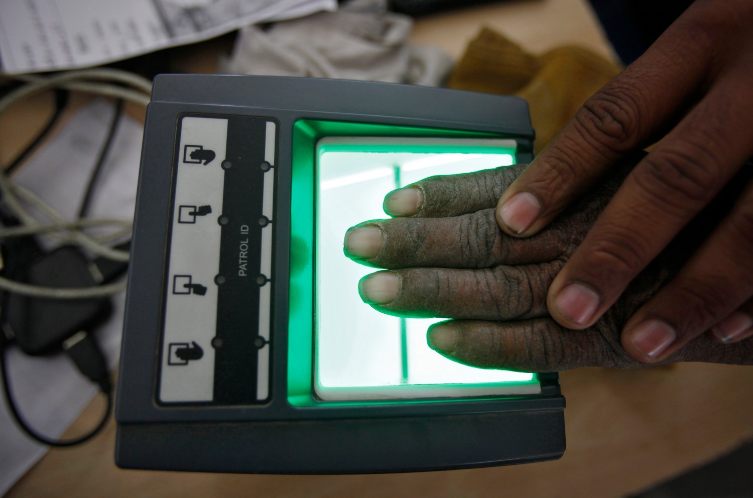 A villager goes through the process of a fingerprint scanner for the Unique Identification (UID) database system at an enrolment centre at Merta district in the desert Indian state of Rajasthan February 22, 2013. In a more ambitious version of programmes that have slashed poverty in Brazil and Mexico, the Indian government has begun to use the UID database, known as Aadhaar, to make direct cash transfers to the poor, in an attempt to cut out frauds who siphon billions of dollars from welfare schemes. Picture taken February 22, 2013. REUTERS/Mansi Thapliyal (INDIA - Tags: BUSINESS SOCIETY POVERTY SCIENCE TECHNOLOGY)