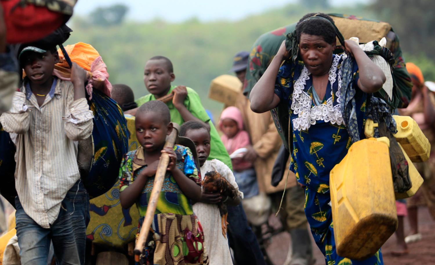 Families flee renewed fighting between Congolese army and M23 rebels near the eastern Congolese city of Goma July 24, 2012. Congolese rebels and government forces traded heavy weapons fire around two eastern villages on Friday, forcing thousands of civilians to flee towards the provincial capital days ahead of a regional summit due to tackle the rebellion. REUTERS/James Akena (DEMOCRATIC REPUBLIC OF CONGO - Tags: CIVIL UNREST POLITICS CONFLICT)