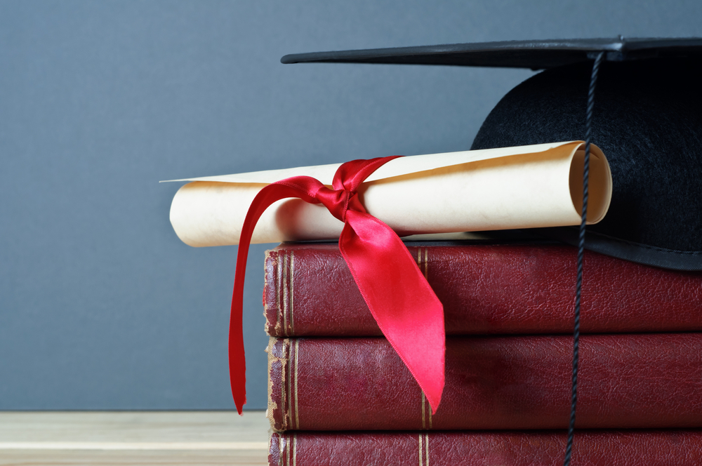 Close,Up,Of,A,Mortarboard,And,Graduation,Scroll,On,Top