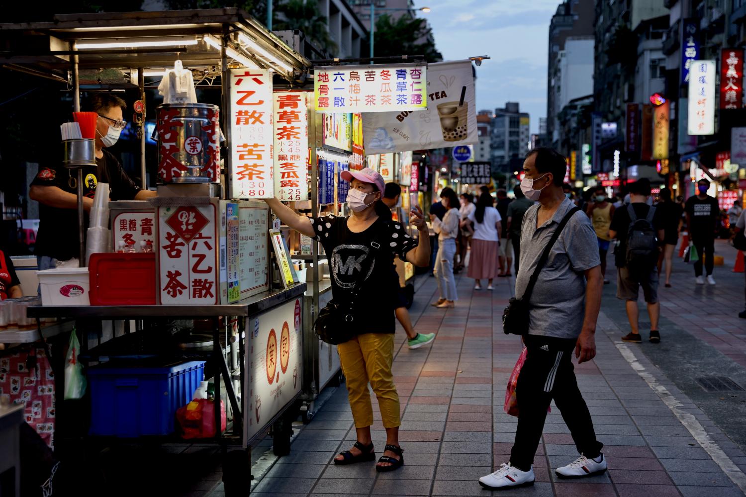 People wearing protective masks pick up their food at a newly opened night market amid the coronavirus disease (COVID-19) pandemic in Taipei, Taiwan, July 2, 2021. REUTERS/Ann Wang