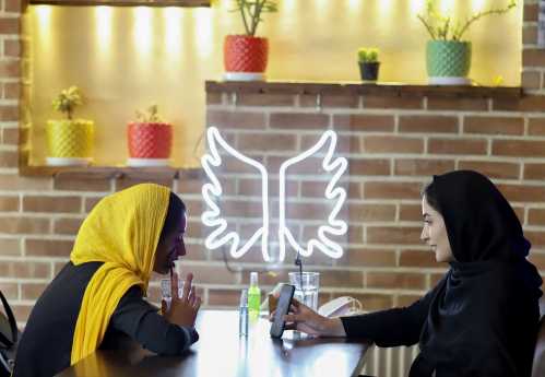 Iranian women sit in a cafe after the launching of the "Hamdam" dating app, in Tehran, Iran, July 17, 2021. Picture taken July 17, 2021. Majid Asgaripour/WANA (West Asia News Agency) via REUTERS ATTENTION EDITORS - THIS IMAGE HAS BEEN SUPPLIED BY A THIRD PARTY.