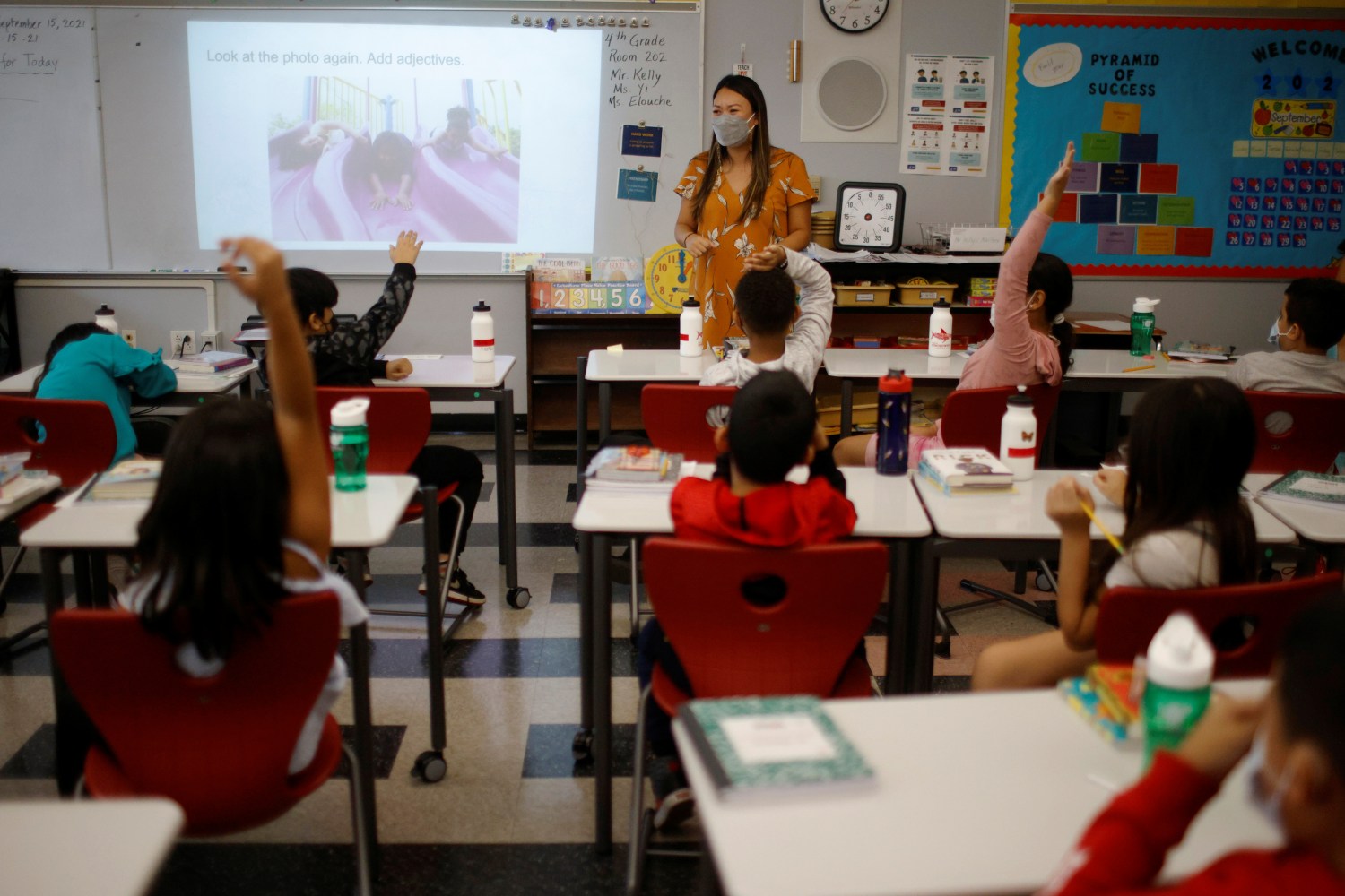 Teacher Mary Yi works with fourth grade students at the Sokolowski School, where students and teachers are required to wear masks because of the coronavirus disease (COVID-19) pandemic, in Chelsea, Massachusetts, U.S., September 15, 2021.   REUTERS/Brian Snyder