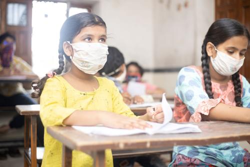 Children in India attend school during COVID.