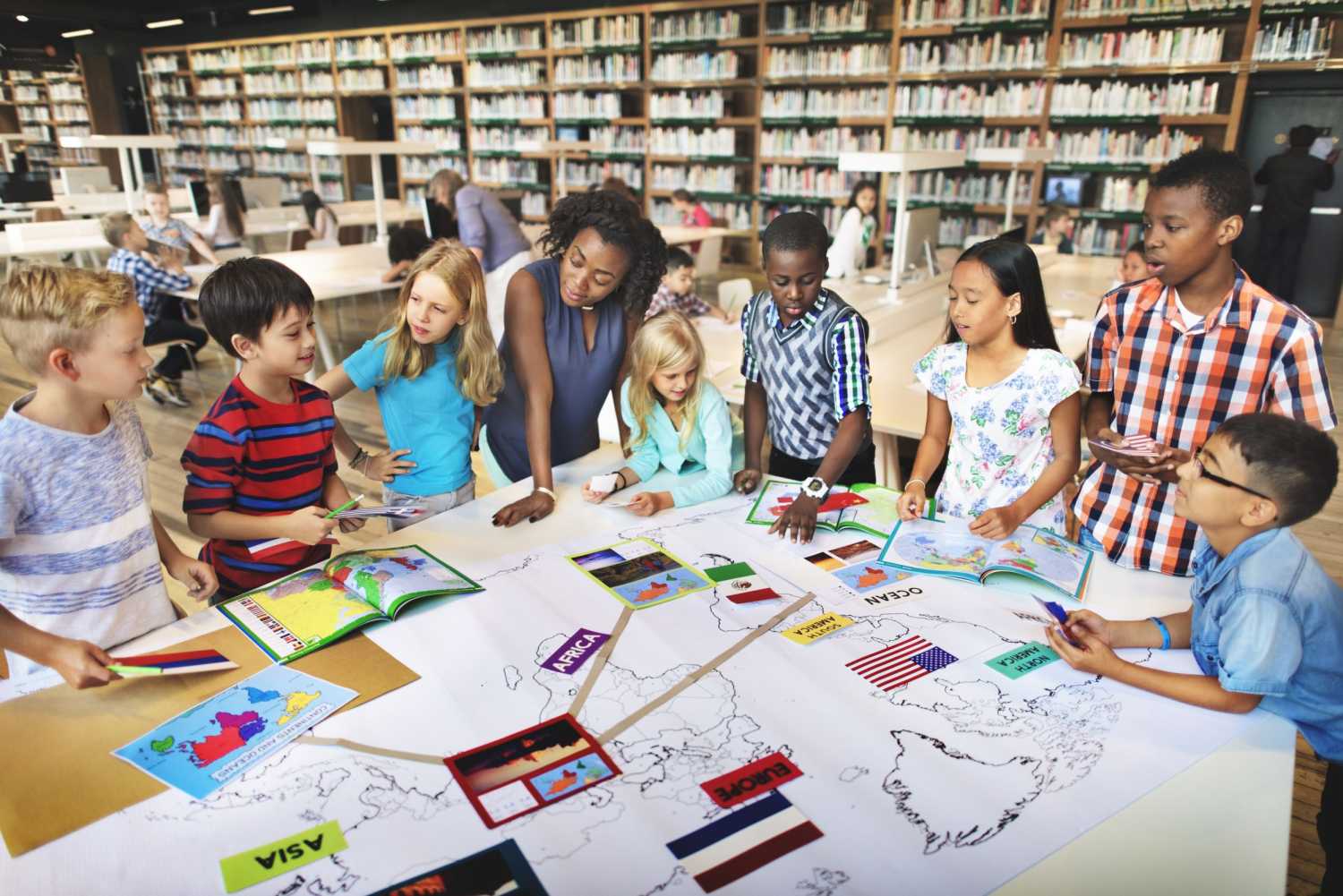 Students and their teacher gather around a handmade map.