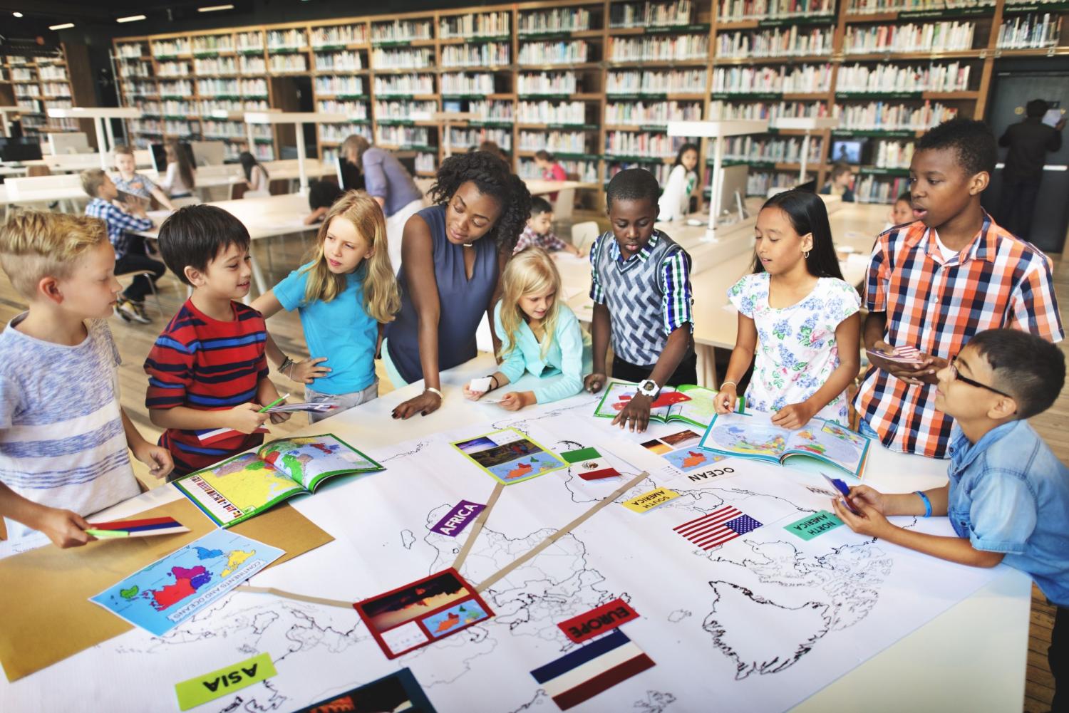 Students and their teacher gather around a handmade map.