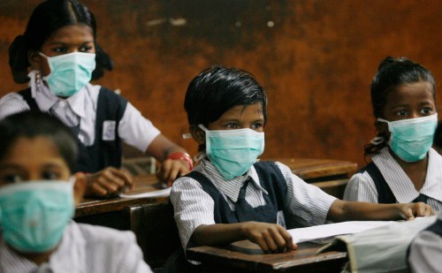 Children wearing masks sit in a classroom at a school in Mumbai August 10, 2009. Masks were distributed by Shiv Sena, the Hindu hardline party, at the school to as a preventive measure against  the H1N1 influenza outbreak in western India.  REUTERS/Punit Paranjpe (INDIA HEALTH SOCIETY POLITICS EDUCATION)