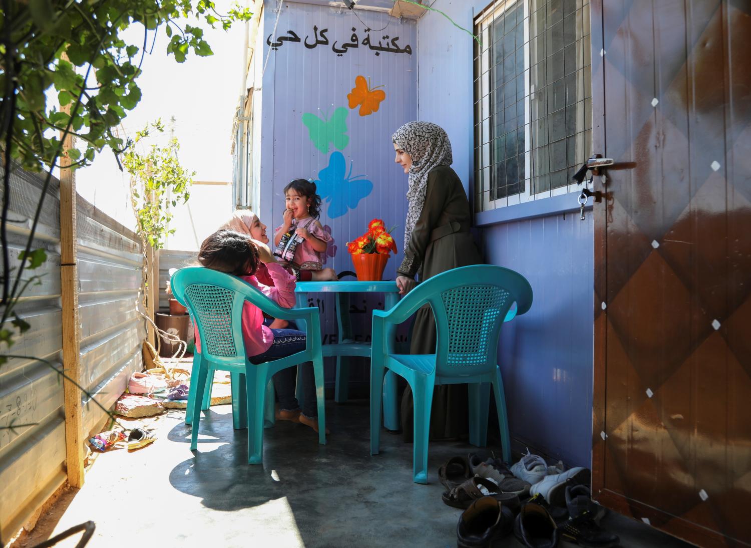 Asmaa Rasheed, a Syrian refugee storyteller living in Zaatari refugee camp, chats with her daughters, at the camp, in the Jordanian city of Mafraq, near the border with Syria, Jordan June 17, 2021. Picture taken June 17, 2021. REUTERS/Alaa Al Sukhni