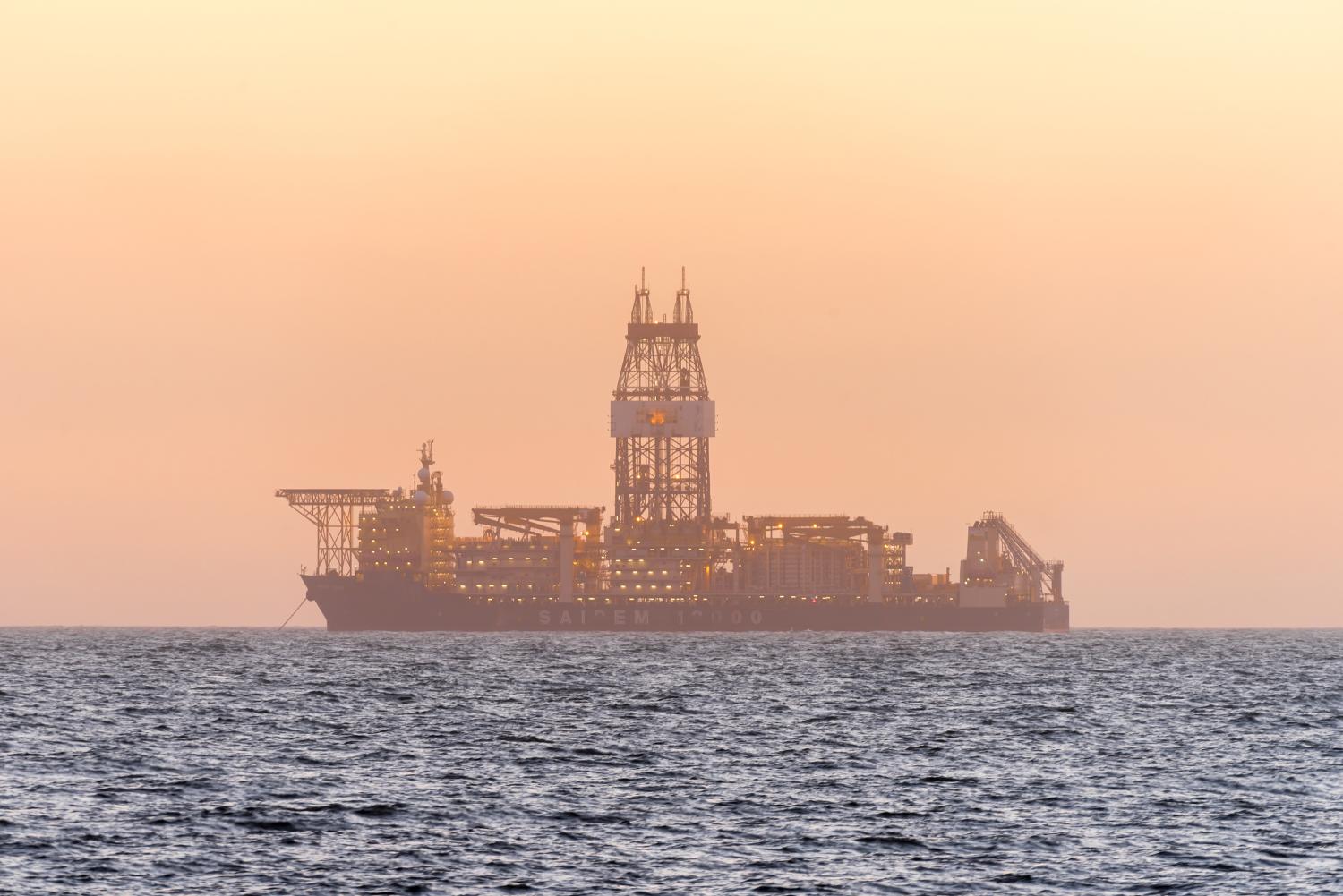 WALVIS BAY, NAMIBIA - JULY 2, 2017: An oil drilling ship anchored after sunset in the Atlantic Ocean at Longbeach in the Namib Desert of Namibia