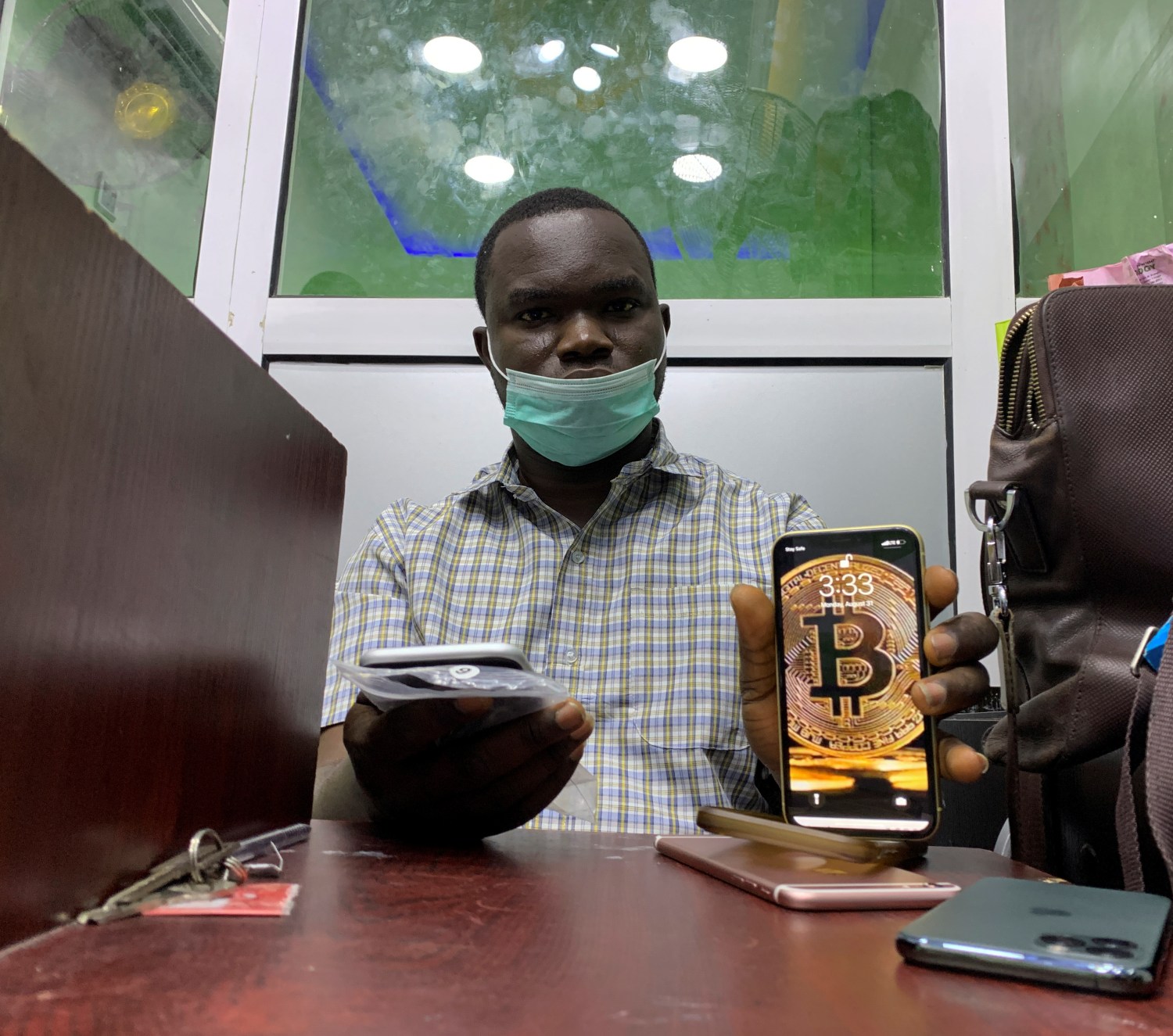 Abolaji Odunjo, a gadget vendor who trades with bitcoin, poses with his mobile phone after an interview with Reuters, at his store at the "Computer Village" in Lagos, Nigeria August 31, 2020. Picture taken in August 31, 2020. REUTERS/Temilade Adelaja