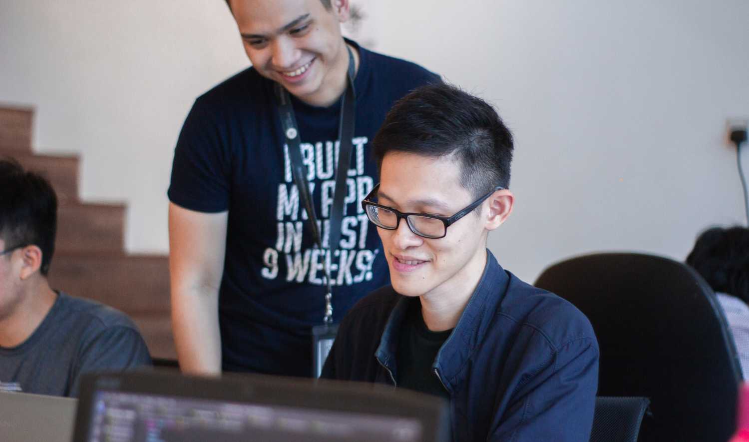Man looks at other man's computer