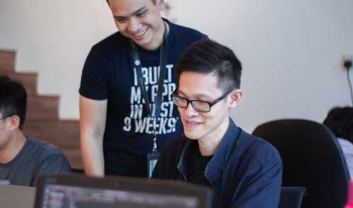 Man looks at other man's computer