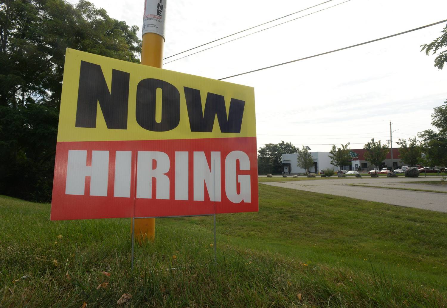 A large "NOW HIRING" sign is pictured outside Zoots in Brockton on Tuesday, Aug. 31, 2021.