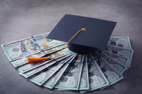 Graduation,Hat,And,Dollar,Banknotes,On,Table.,Tuition,Fees,Concept