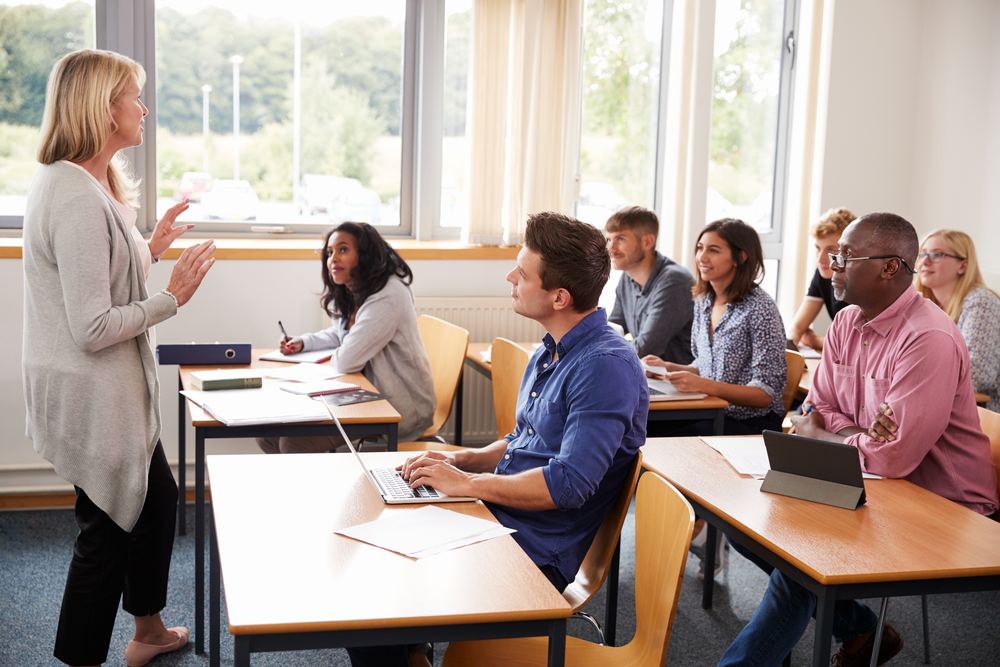 A woman teaching a class of mature students.