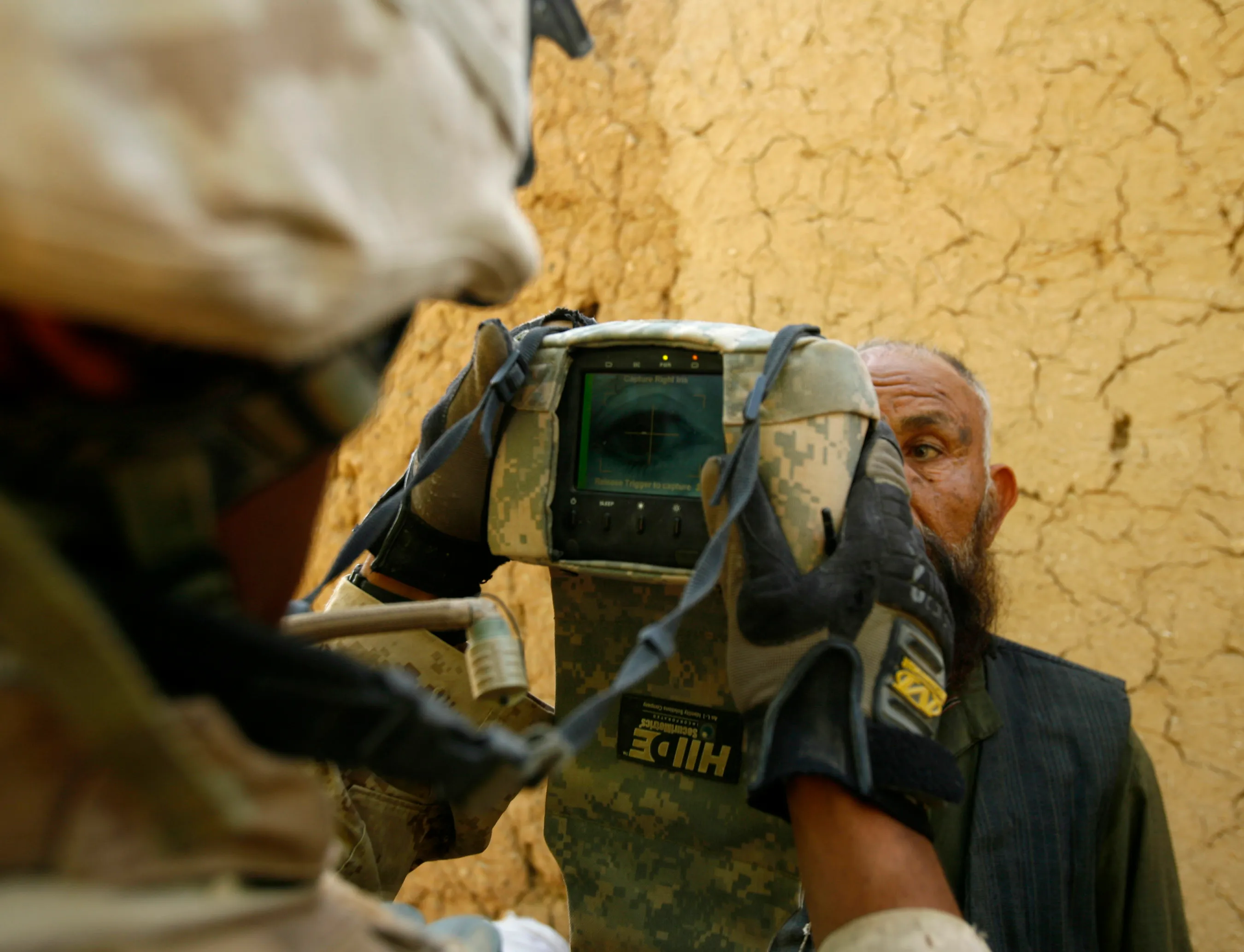 A U.S. Marine from Lima company 3rd Battalion 6th Marines conducts an eye scan with a HIIDE (Handheld Interagency Identity Detection Equipment) camera as a part of a census operation during a patrol around the area of Karez-e-Sayyidi in Helmand province April 4, 2010. REUTERS/Asmaa Waguih (AFGHANISTAN - Tags: CIVIL UNREST MILITARY)
