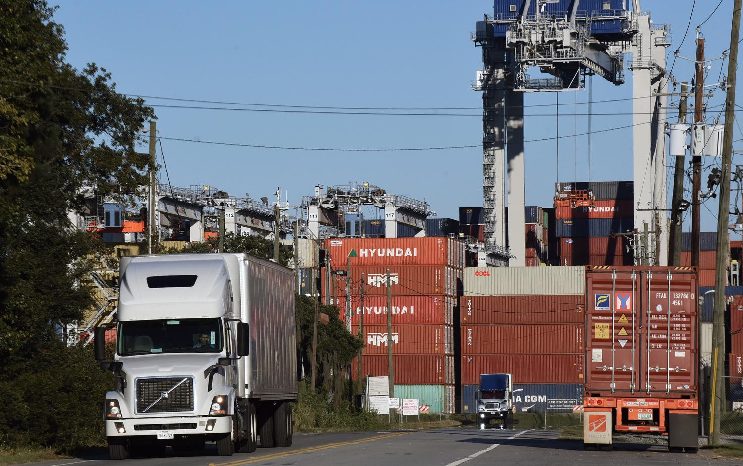 Trucks pick up shipping containers at the Port of Savannah in Georgia. The supply chain crisis has created a backlog of nearly 80,000 shipping containers at this port, the third-largest container port in the United States, with around 20 ships anchored off the Atlantic coast, waiting to offload their cargo. A shortage of truck drivers to transport goods from warehouses to retailers has caused shipping containers to be backed up at the port. (Photo by Paul Hennessy / SOPA Images/Sipa USA)No Use Germany.