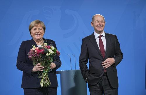 Chancellor Olaf Scholz hands over a bouquet of flowers during the handover of office from former Chancellor Angela Merkel (CDU) to newly elected Chancellor Olaf Scholz (SPD) at the Federal Chancellery.