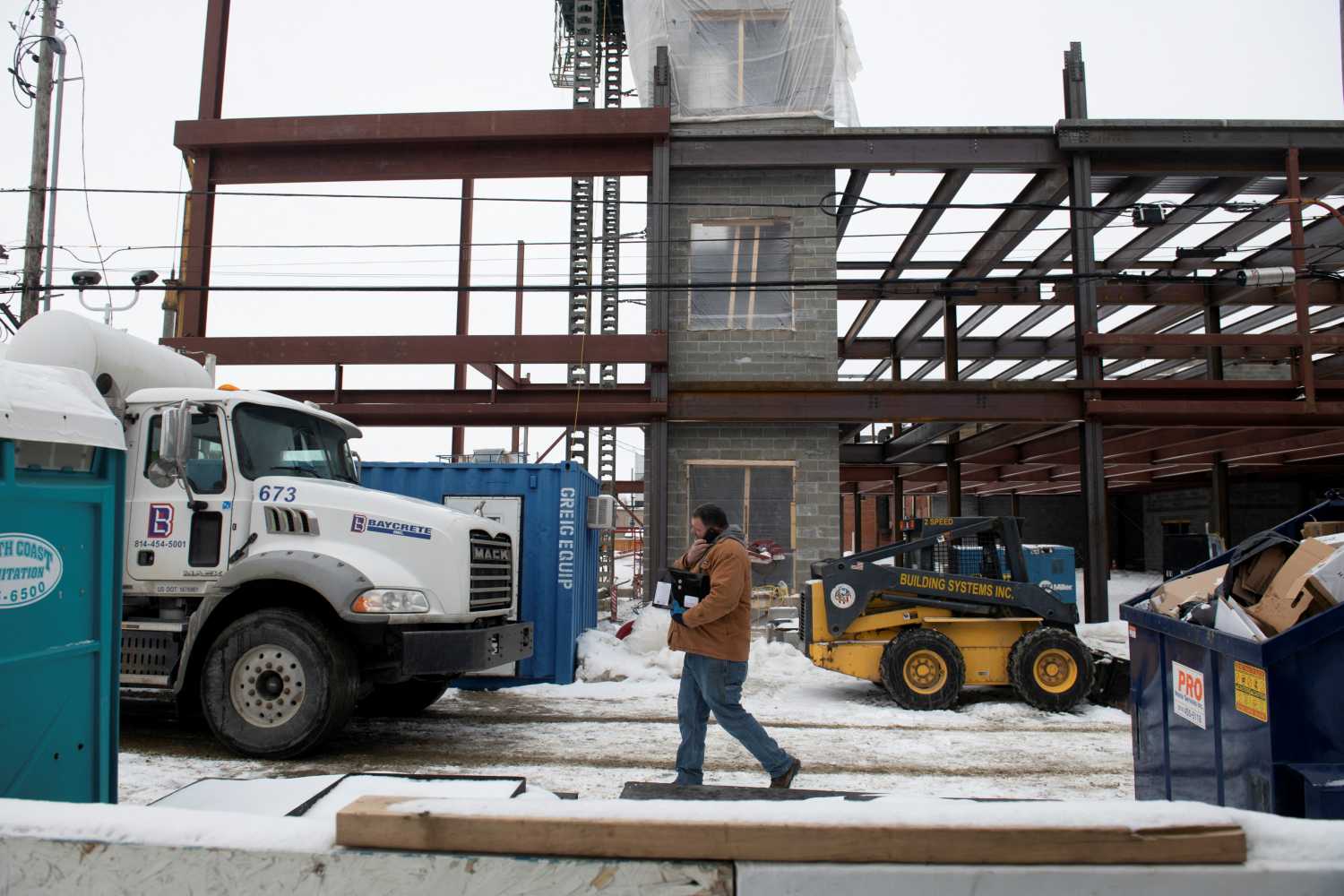 Workers finish the day at the site of new mixed-use construction in downtown Erie, Pennsylvania, U.S., February 8, 2022. City leaders are hoping to get a piece of the $500 billion promised through President Biden's infrastructure bill to continue their vision to revitalize their downtown and waterfront areas, moving the city forward from its industrial past. Picture taken February 8, 2022. REUTERS/Stephanie Strasburg
