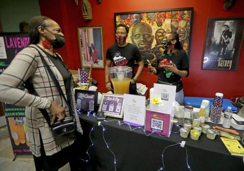 Robert Brox, center, and his wife, Jolie Brox, co owners of Fit 4 You MKE discuss their lavender lemonade and health products at their booth set up as part of the annual Kwanzaa celebration at the Wisconsin Black Historical Society on West Center Street in Milwaukee on Sunday. The annual celebration of African American culture featured speakers, various food vendors and dancing and drumming.Kwanzaa 4310