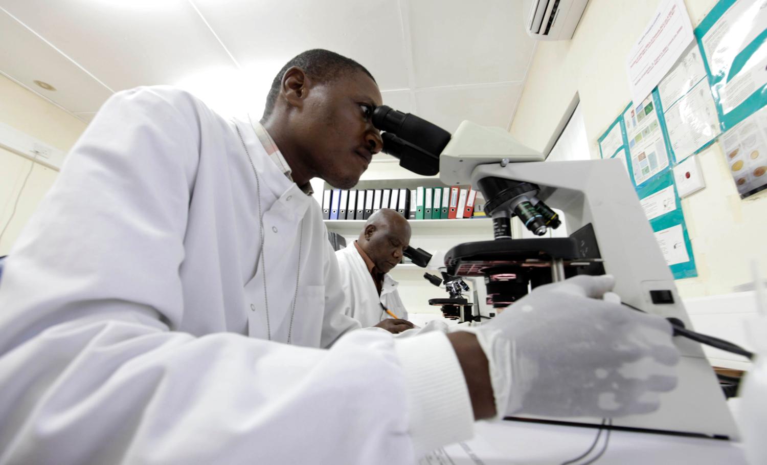 Kenya Medical Research Institute doctors research malaria at the clinical research facility laboratory in the Kenya coastal town of Kilifi, November 23, 2010. Malaria threatens half the people on the planet and kills around 800,000 people a year, many of them too young to have even learned to walk. The death rate has come down in the last decade, but full-scale eradication will cost billions and drag funds away from other equally, or possibly even more urgent health efforts. As governments in poor countries and donors from wealthy ones weigh up where to put their money, experts have begun a quiet but fundamental debate about whether wiping out malaria is realistic or even makes economic sense.Picture taken November 23, 2010.   To match Special Report MALARIA/COST     REUTERS/Joseph Okanga (KENYA - Tags: BUSINESS HEALTH)